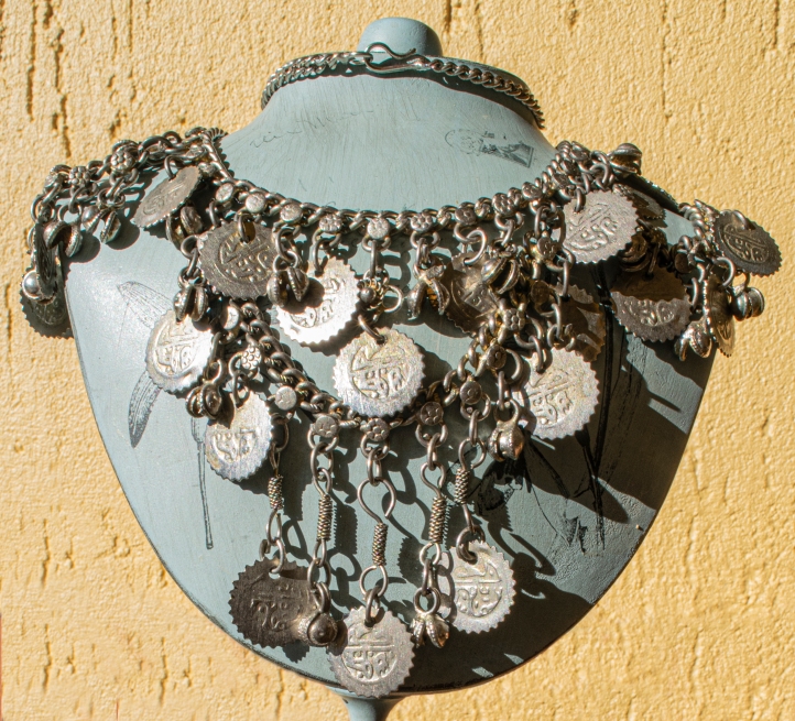 Image of Arabic coin necklace on necklace stand. Image by Maria Shaw